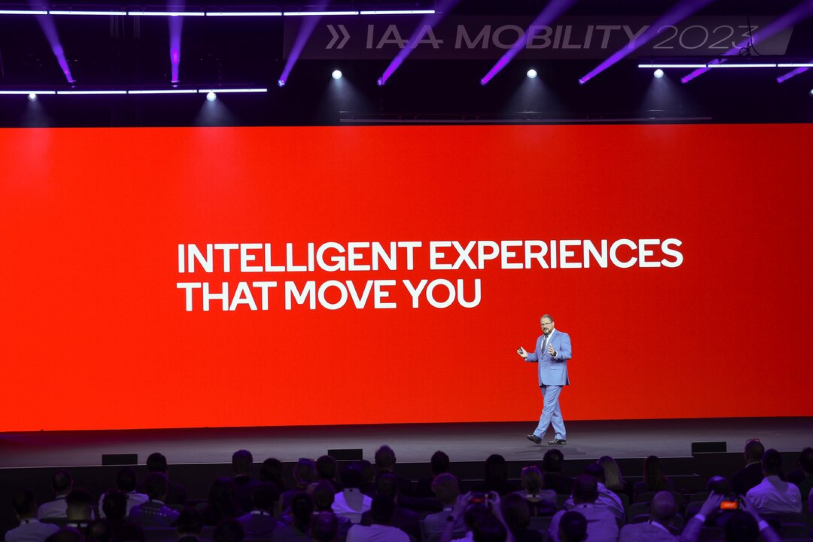 Man in front of red background that reads 