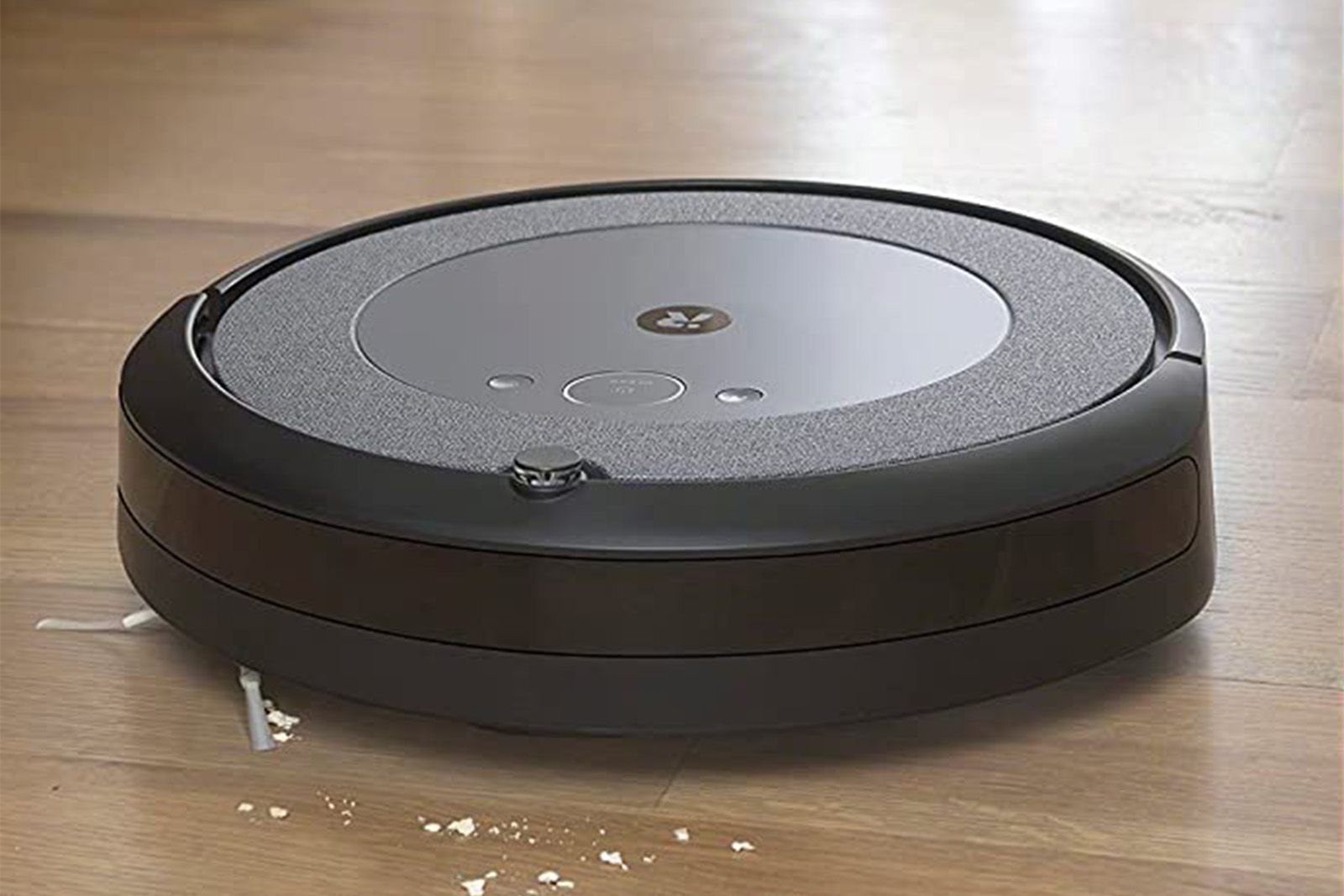 An iRobot Roomba i4 vacuums a messy hardwood floor. 