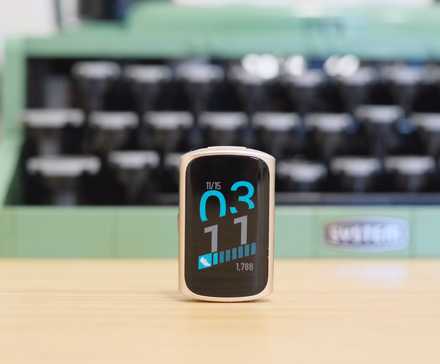 一台 Fitbit Charge 6 放在一台绿色打字机前