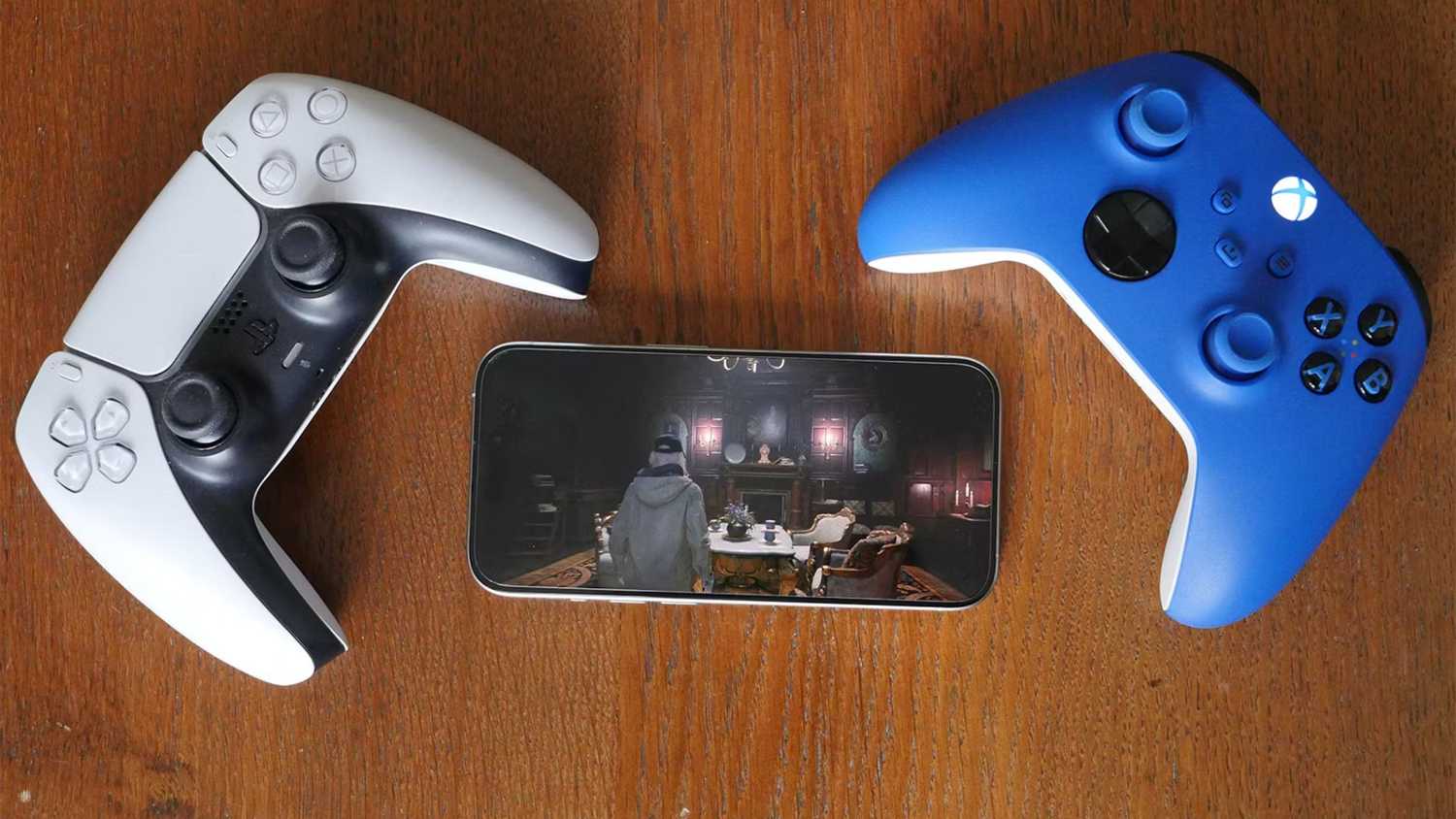 A white controller and a blue controller beside an iPhone.