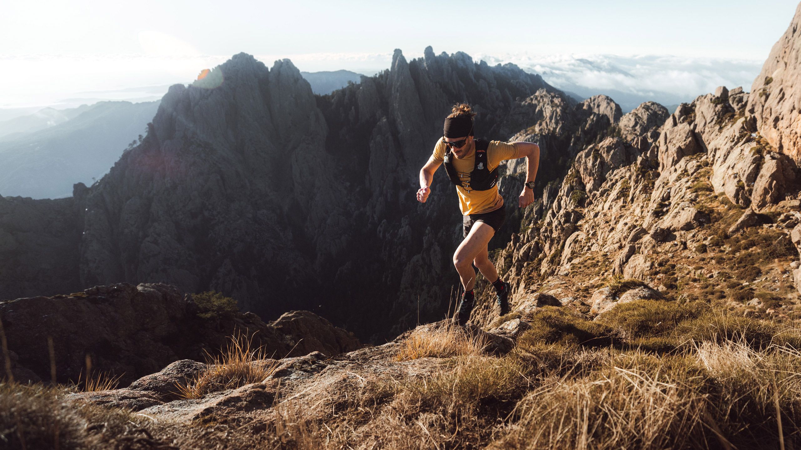 A man runs along a mountain trail with their Polar Grit X2 Pro watch