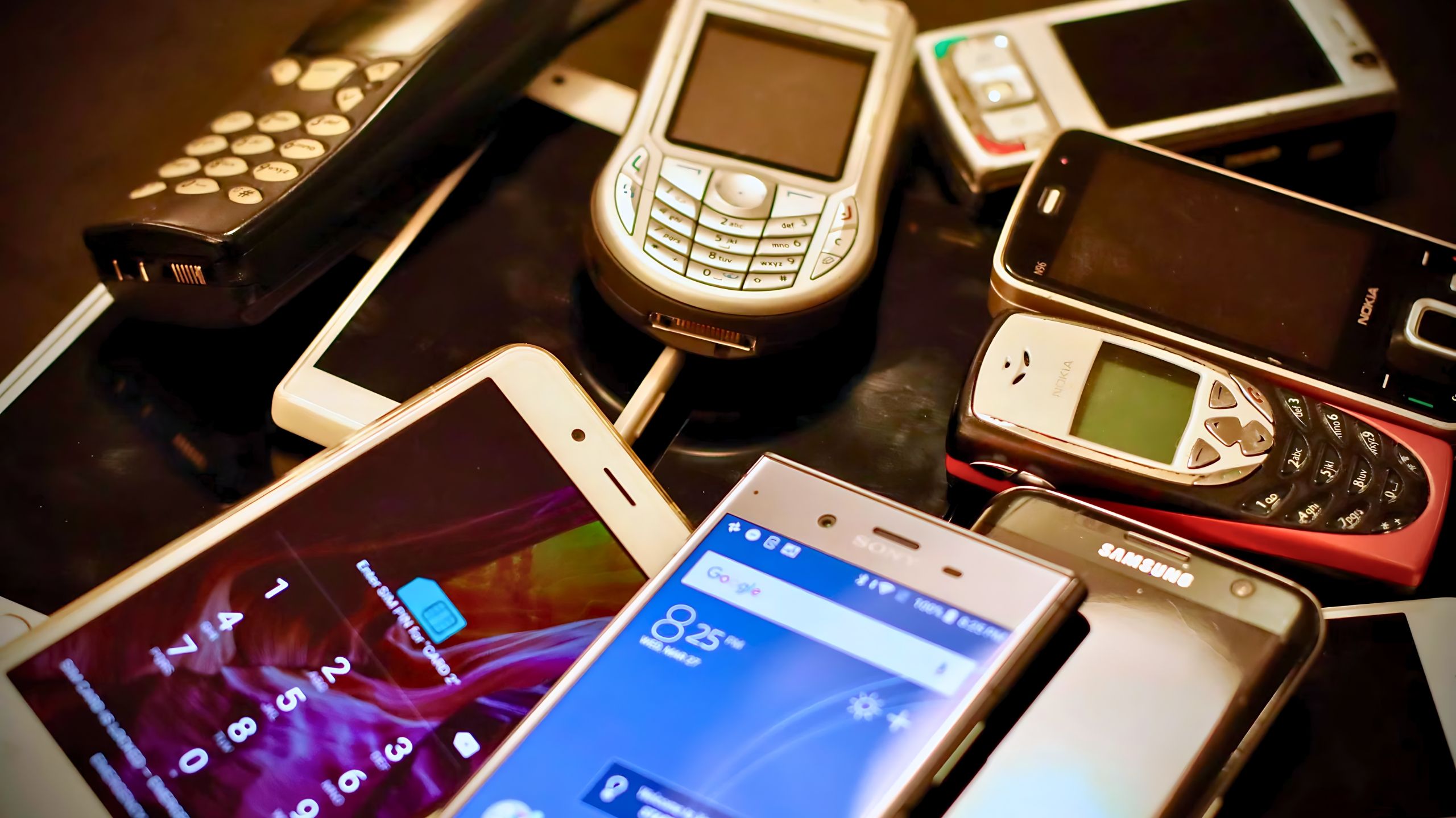 unsplash many older phones stacked from Nokia, Android and Apple