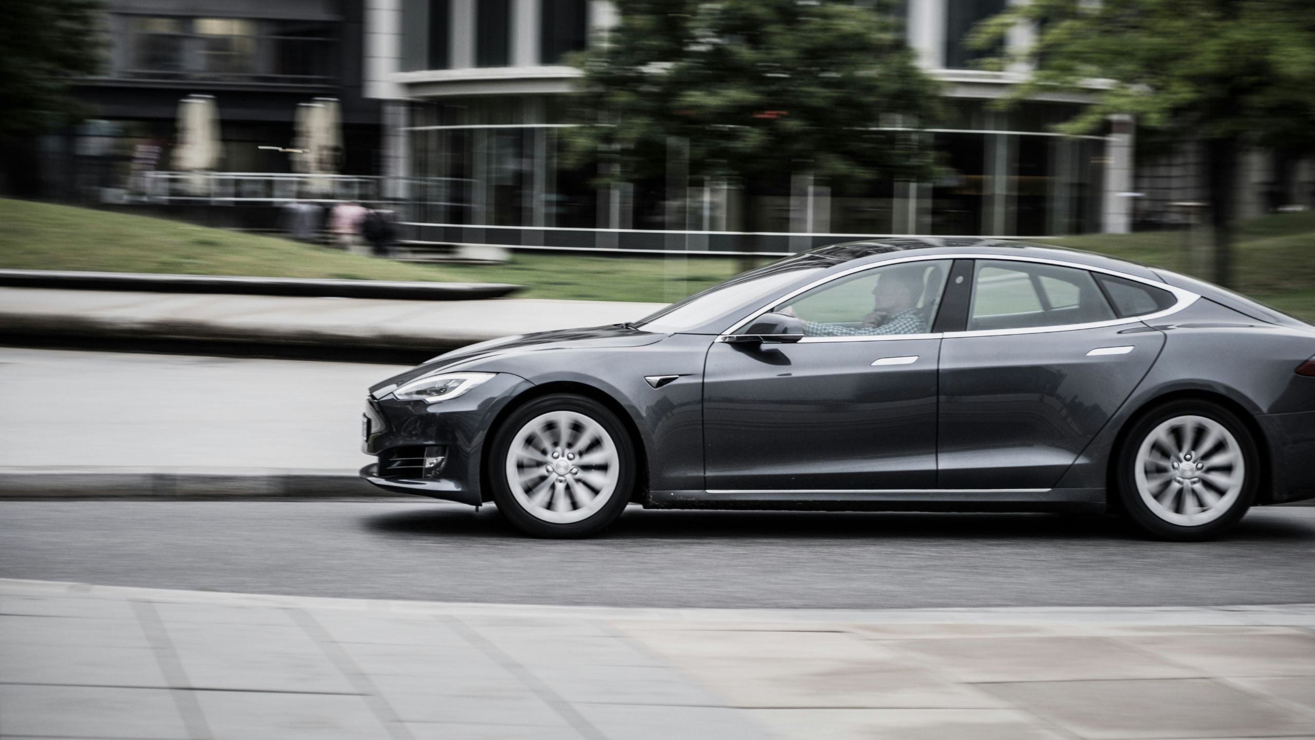 Tesla sedan driving through a neighborhood