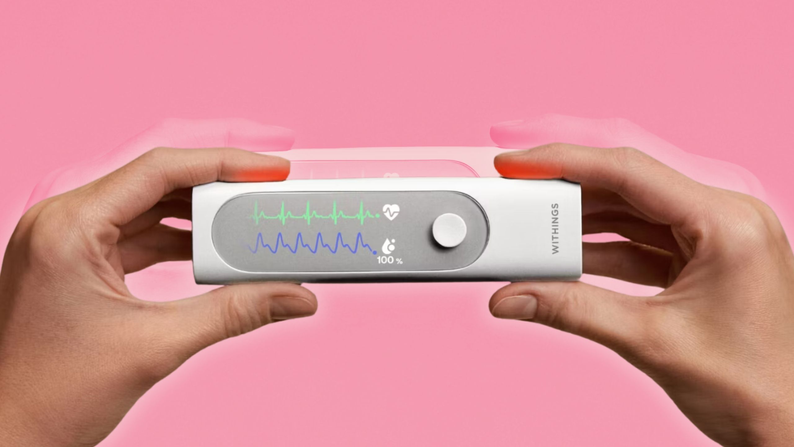 Two hands holding a Withings BeamO device with graphics on the screen.