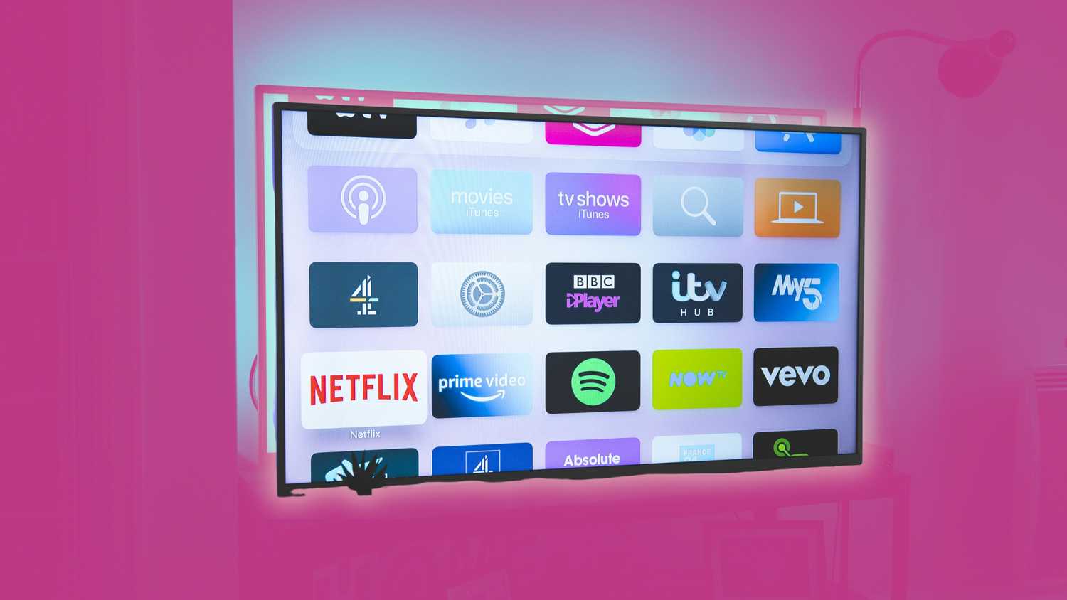 Smart TV apps on a TV on a pink background. 