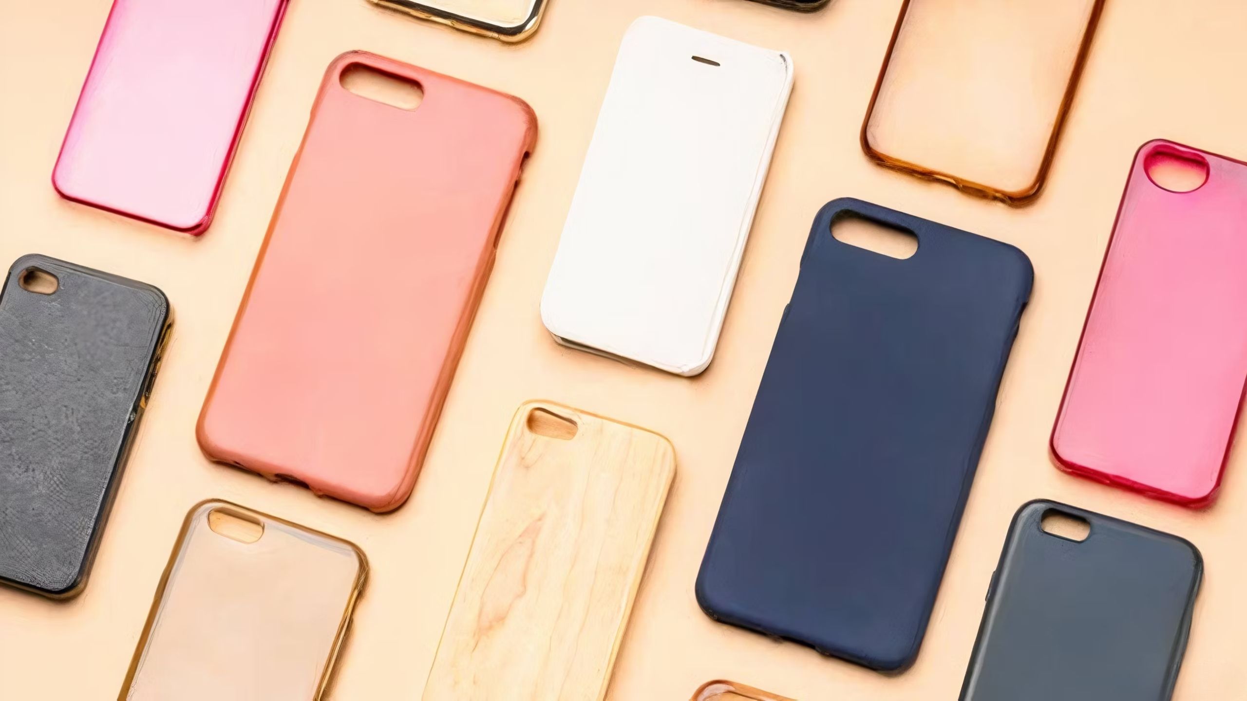 Phone cases of all sizes and colors organized on a beige surface. 