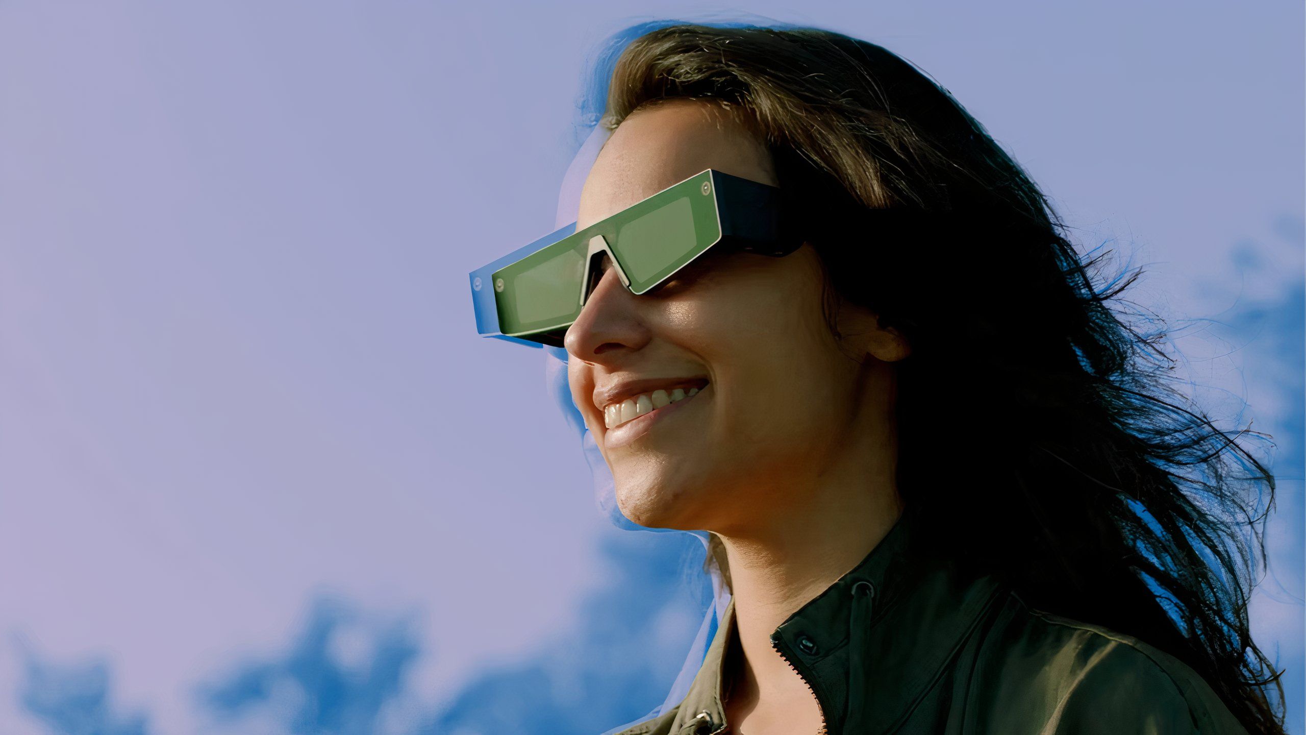 A person wearing Snap AR Spectacles outside and smiling.