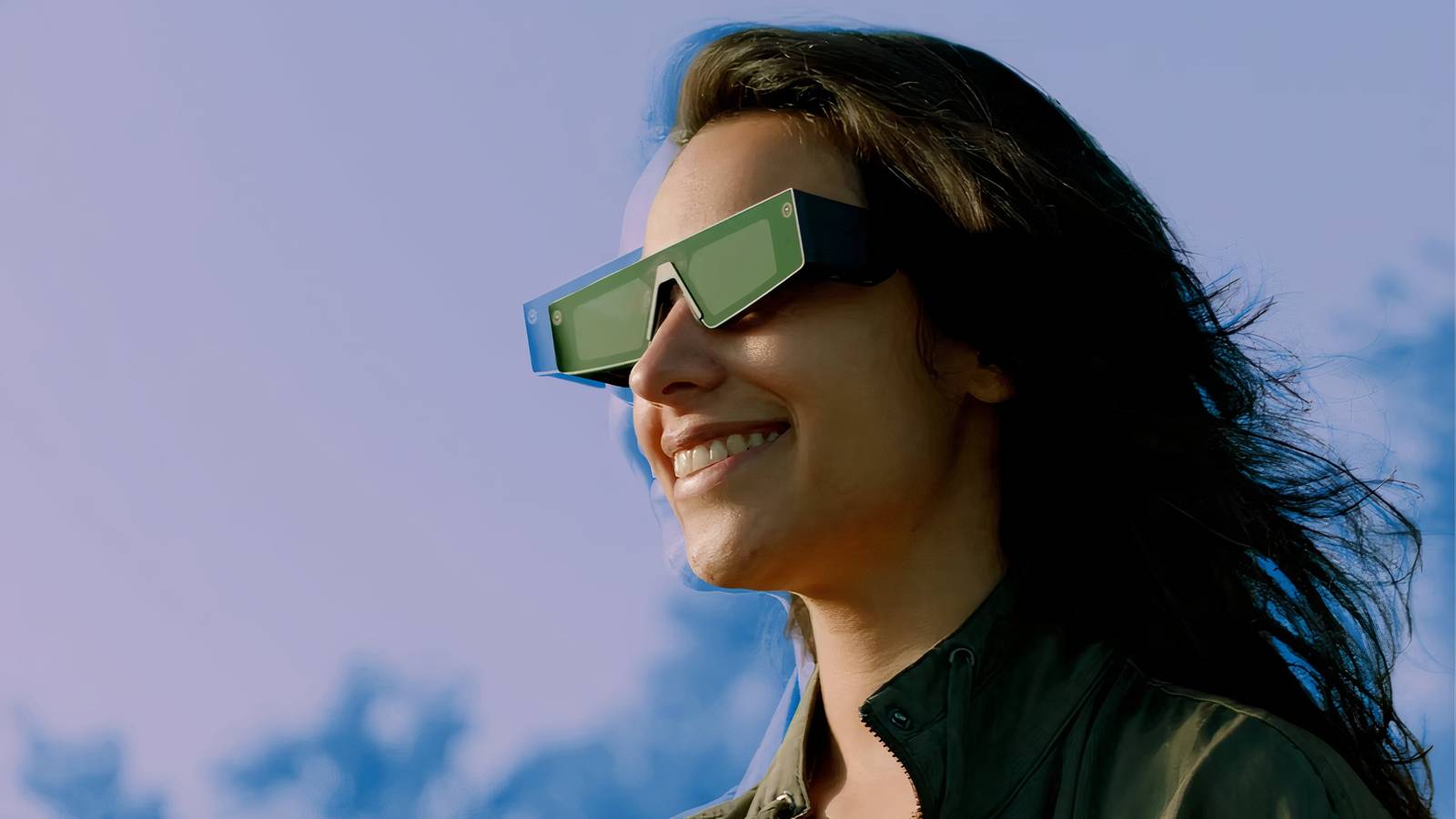 A person wearing Snap AR Spectacles outside and smiling.
