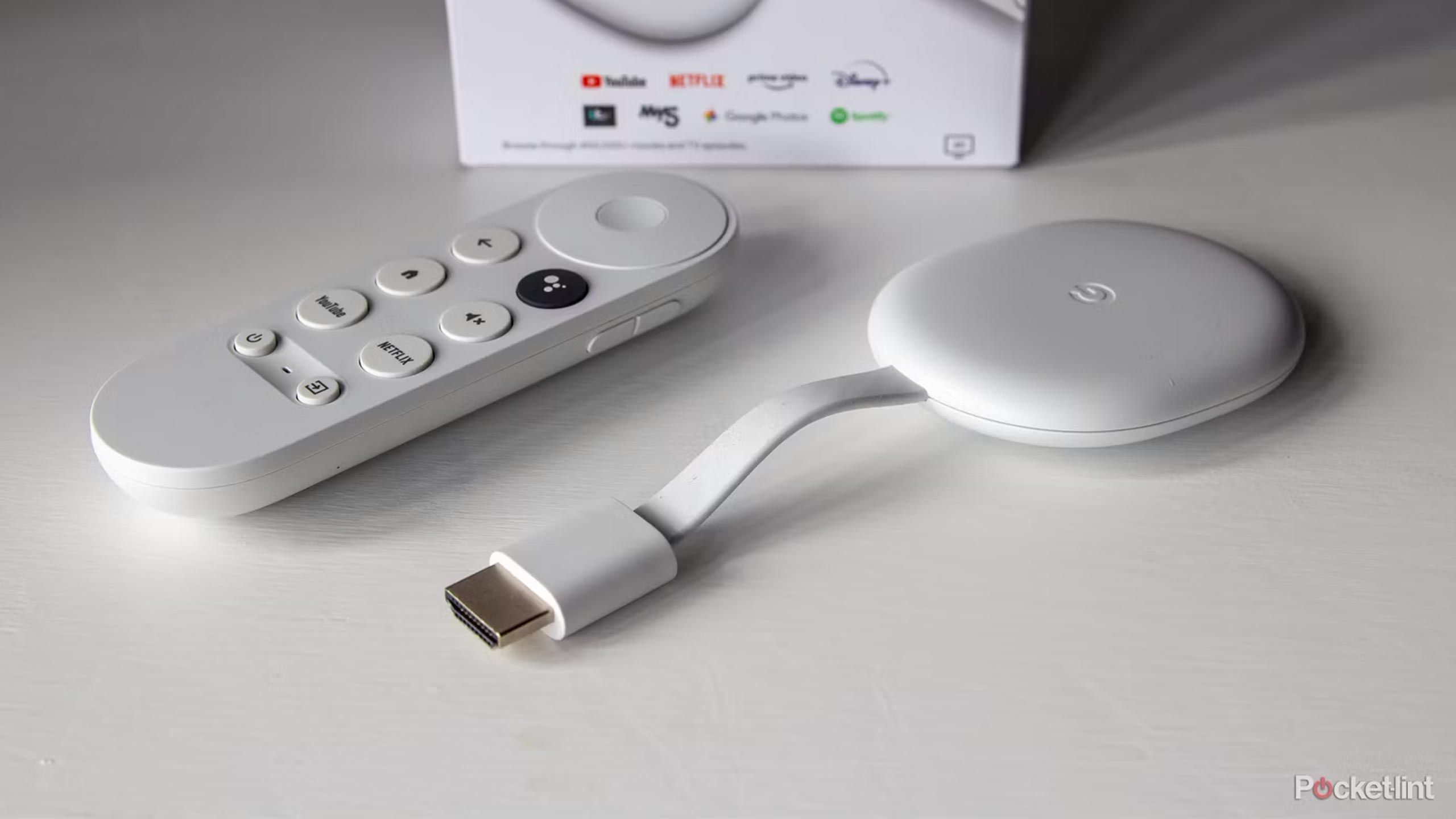 A Chromecast with Google TV sits on a white table