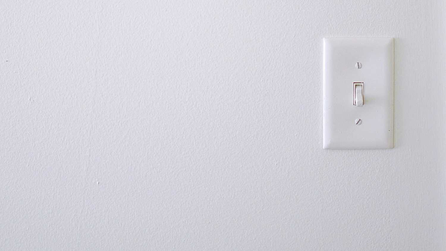 A light switch on a white wall