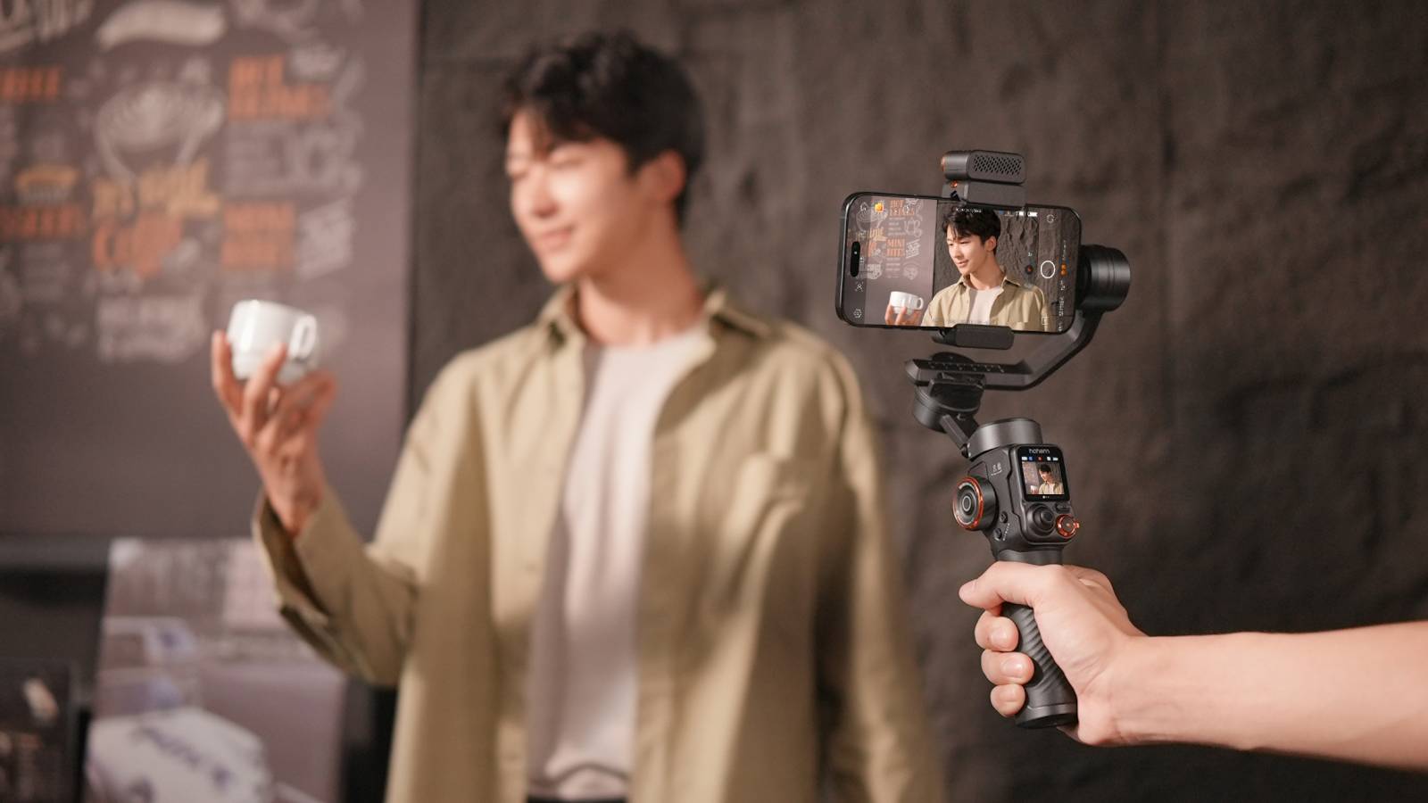 Filming man holding coffee cup with the Hohem iSteady M7