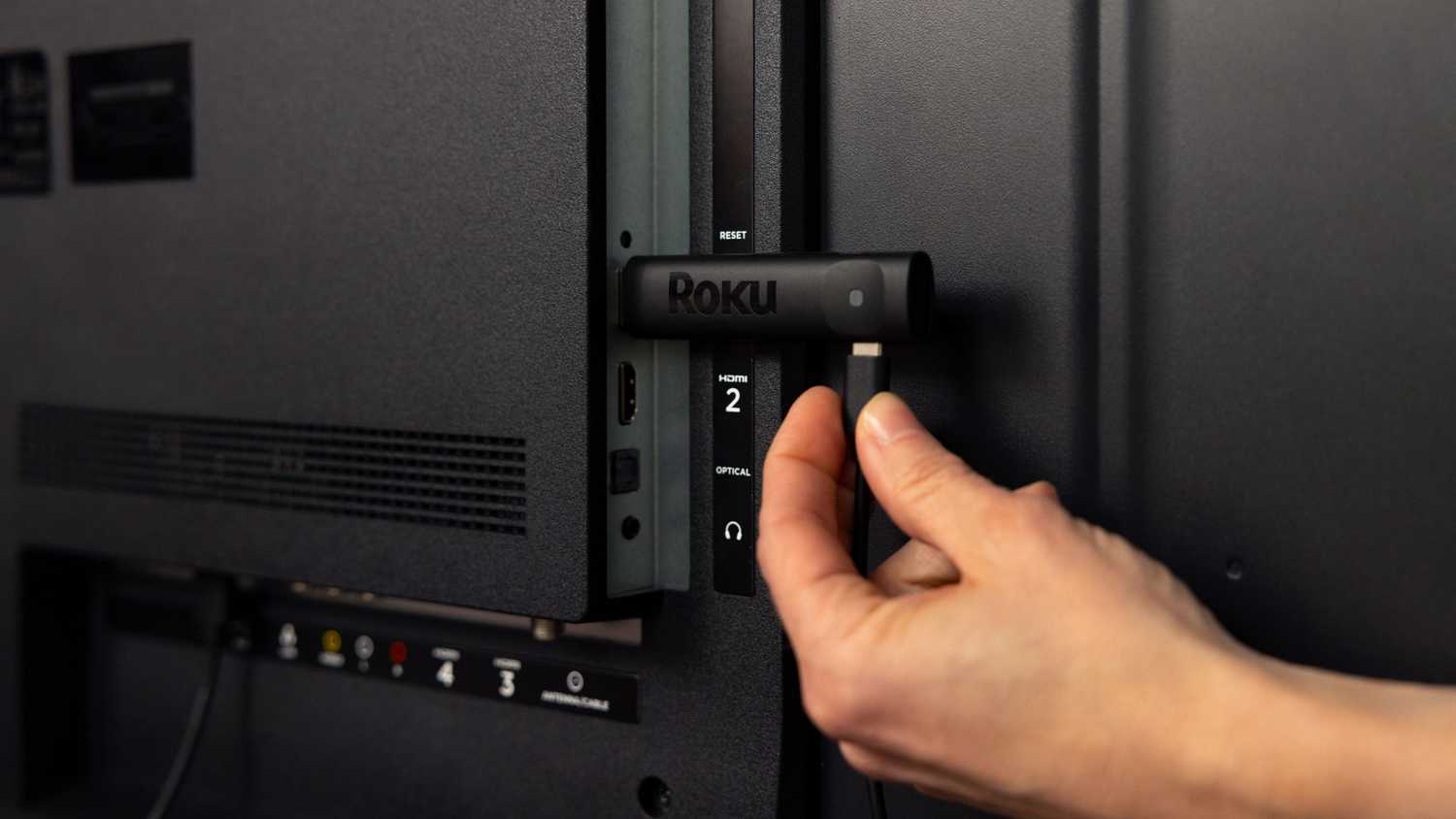 A Roku Streaming Stick being plugged in.