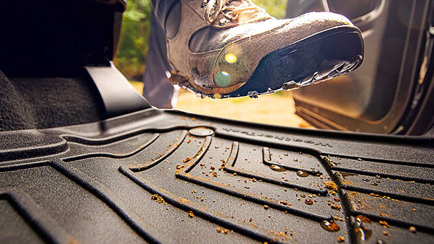 WeatherTech floor mats being stepped on by a dirty shoe. 
