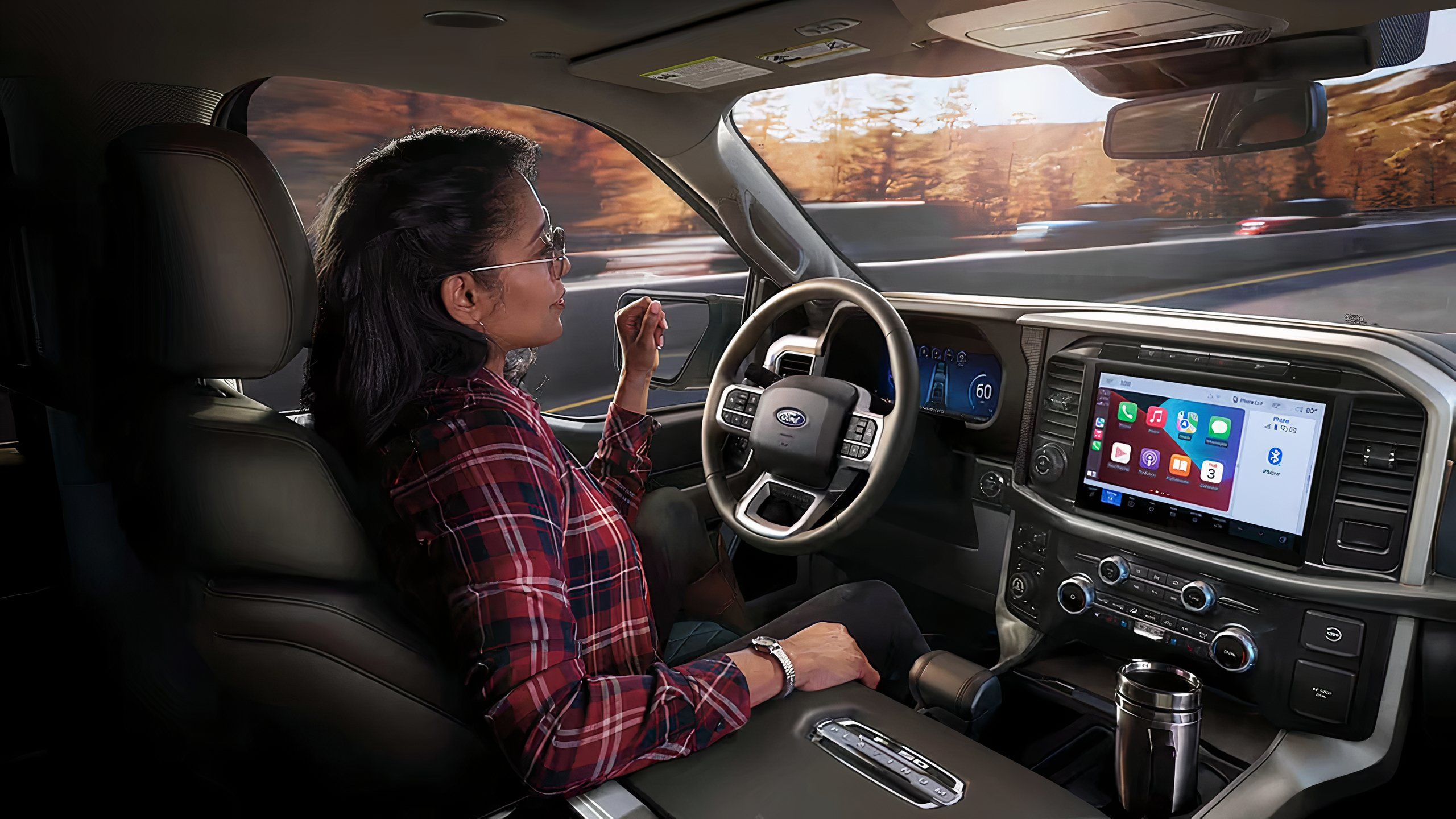 A woman in her vehicle using Ford's Blue Cruise hands free driving mode. 