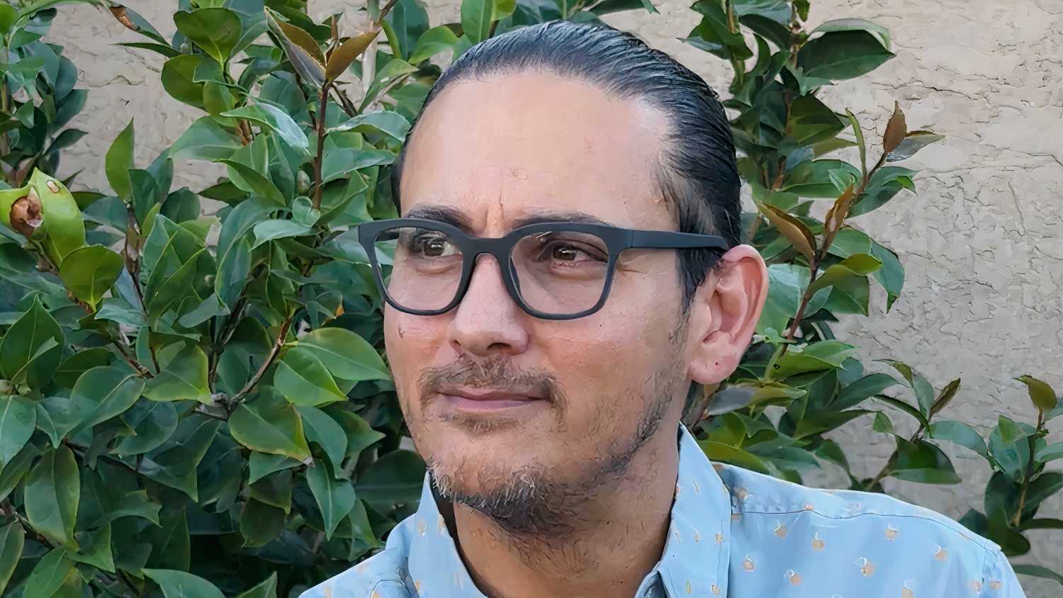 A person wearing black Brilliant Labs Halo smart glasses and looking to the left.