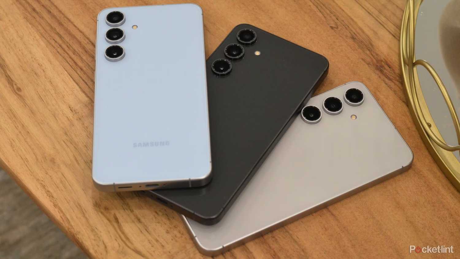 Three Samsung Galaxy S24 FEs on a table. 