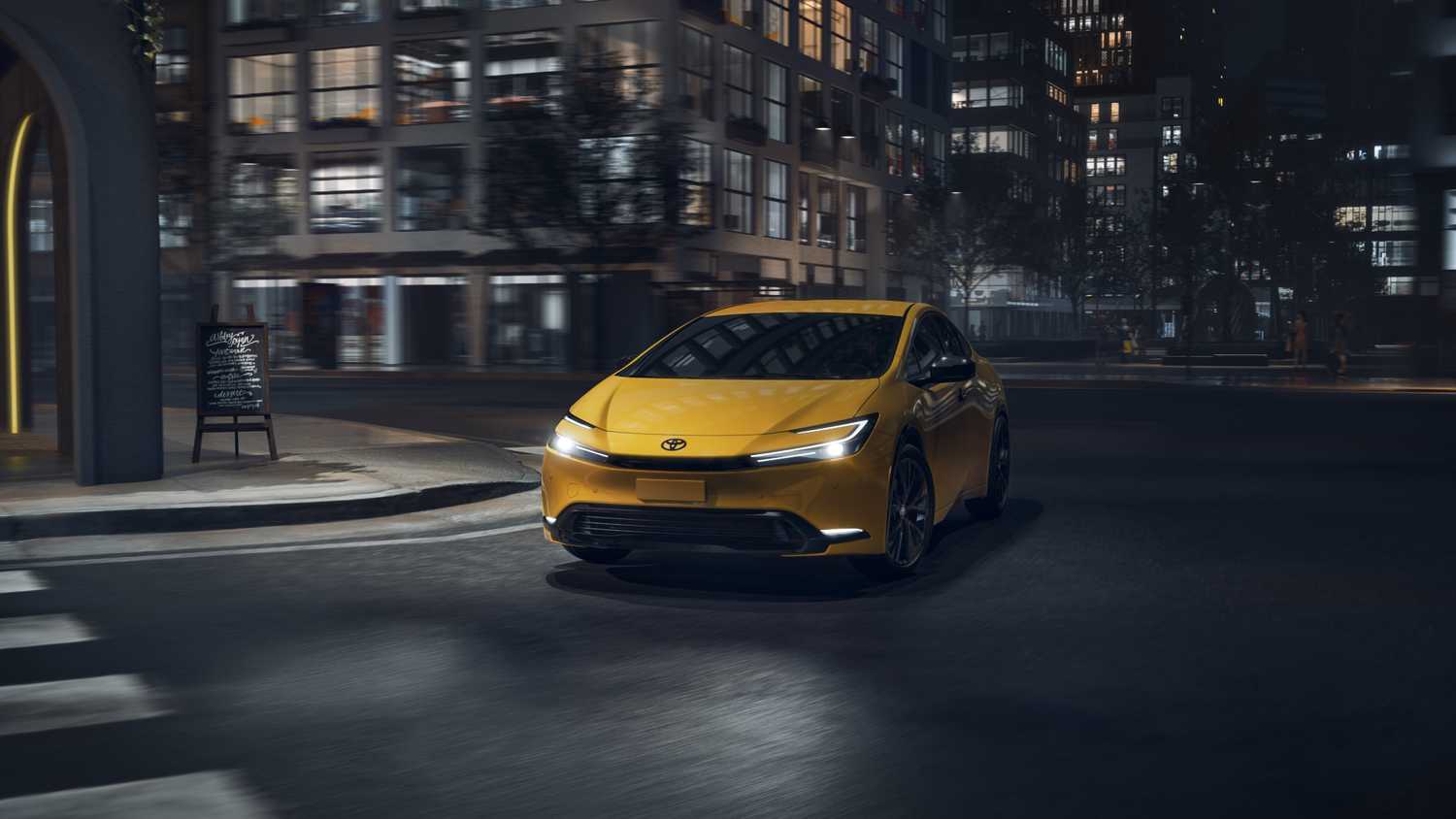 A still photo of a 2026 Toyota Prius driving down a dark street.