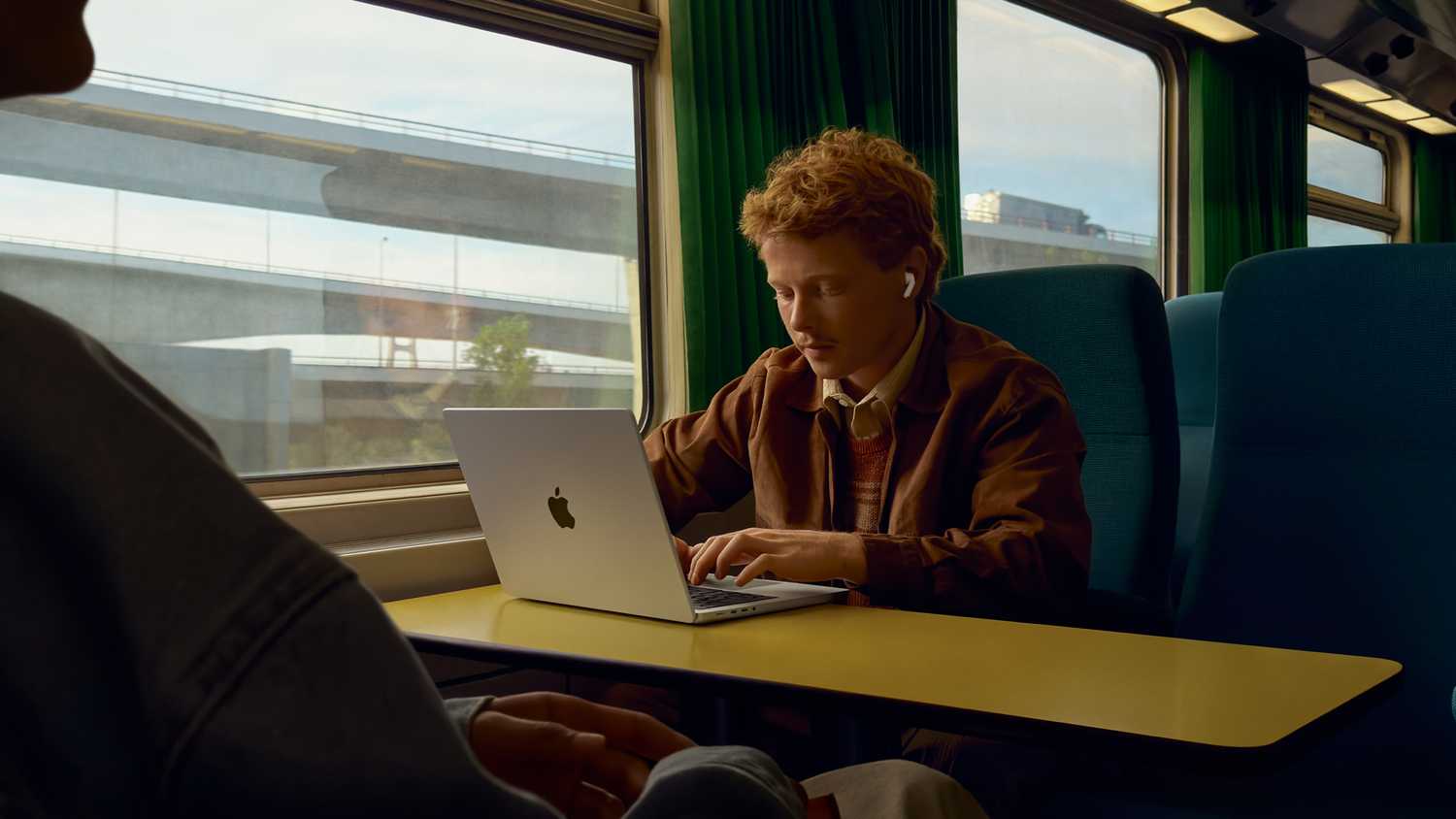 Person wearing AirPods Pro 3 on train