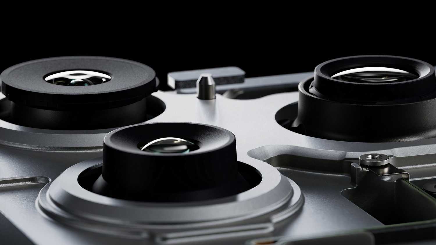 The wide, ultrawide, and telephoto cameras on the back of an iPhone 17 Pro with its back removed.