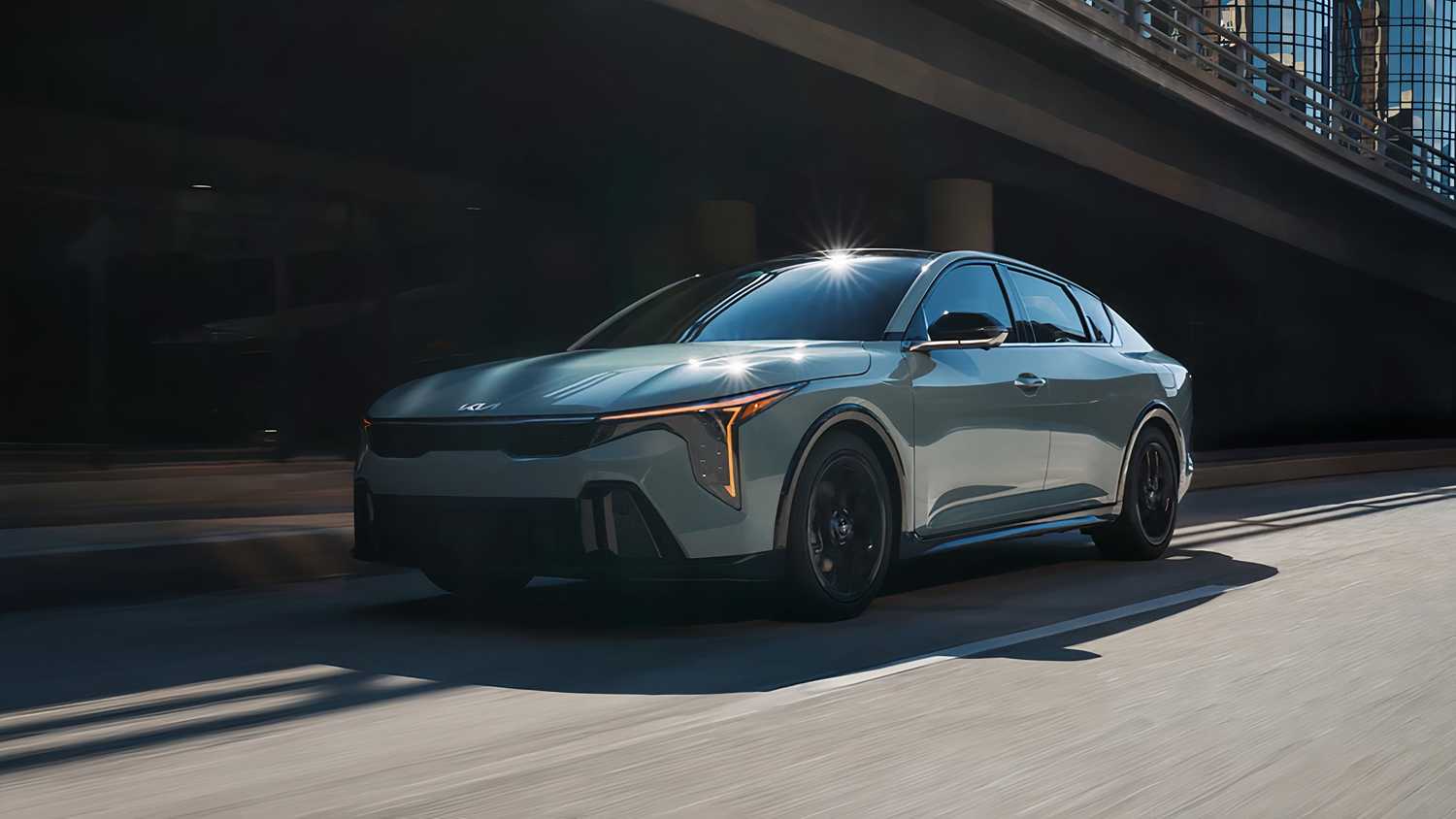 A still photo of the 2025 Kia K4 driving down the street. 