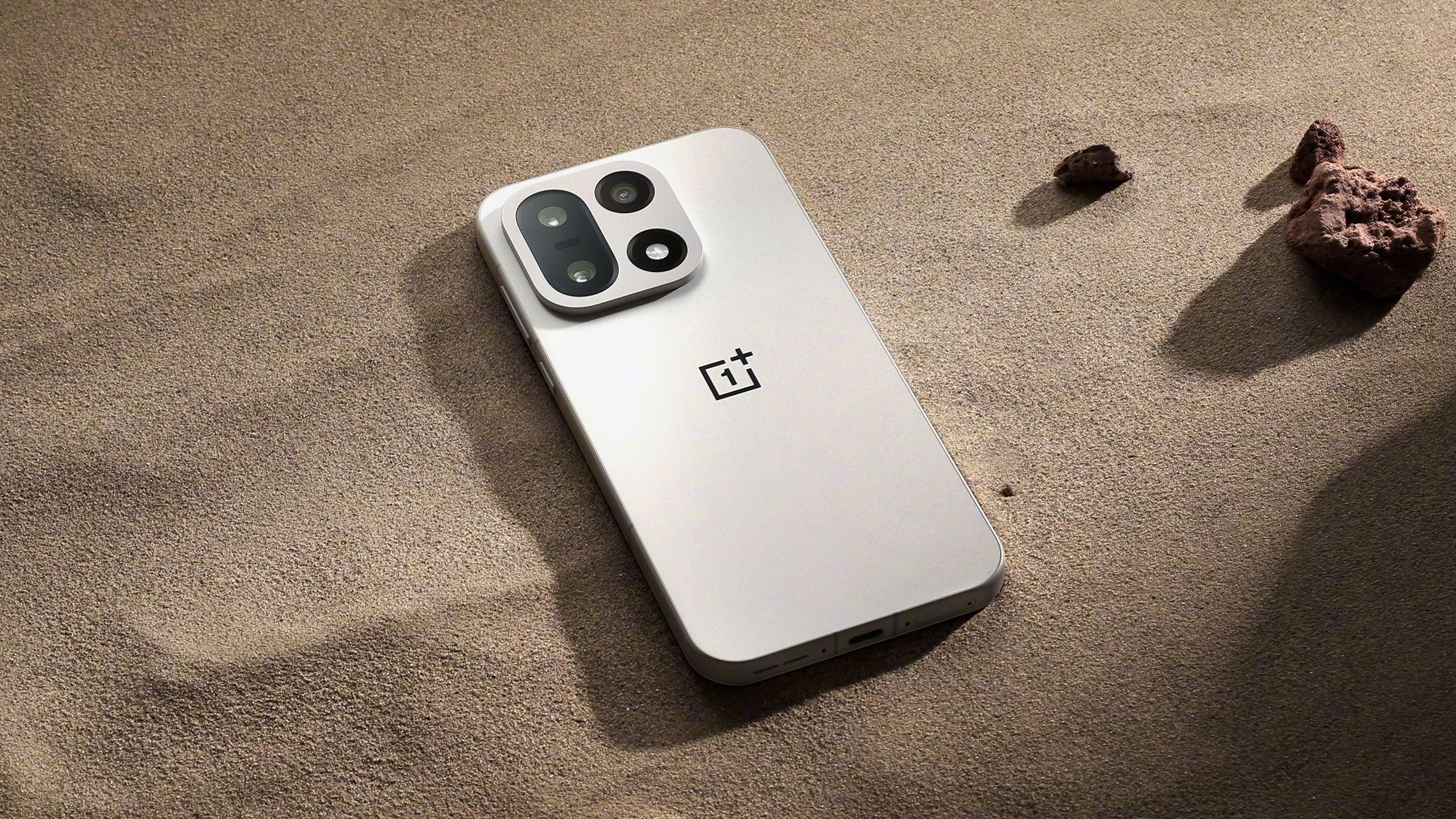 OnePlus 15 in sand.