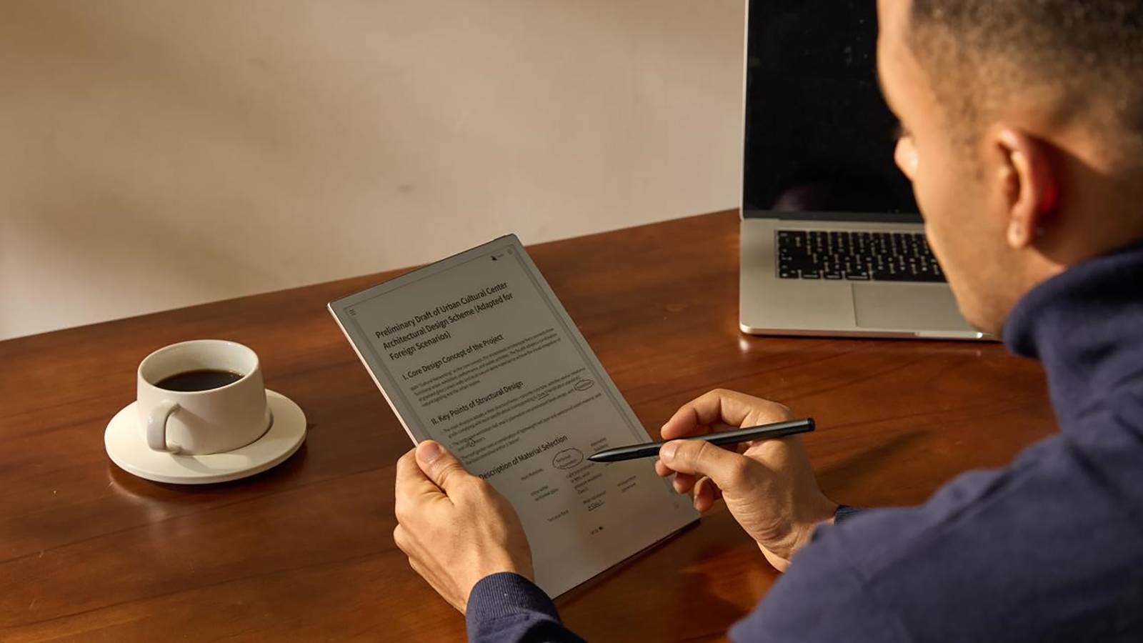 The iFlyTek AINOTE 2 E-ink tablet and smartpen in someone's hands.