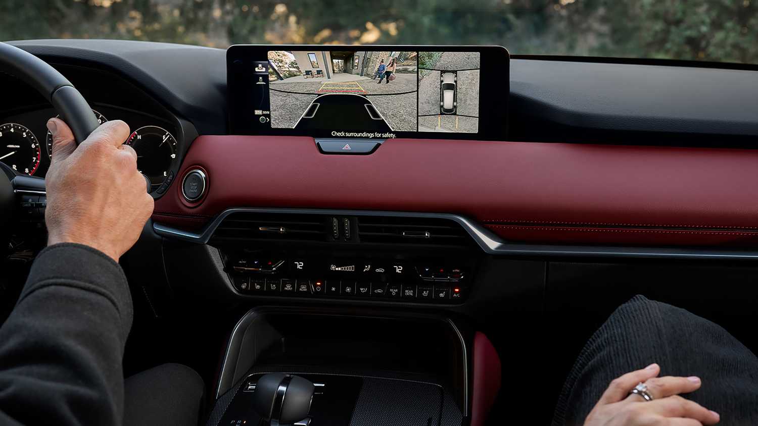 A still photo of a driver reversing with the backup cameras in the Mazda CX-70.