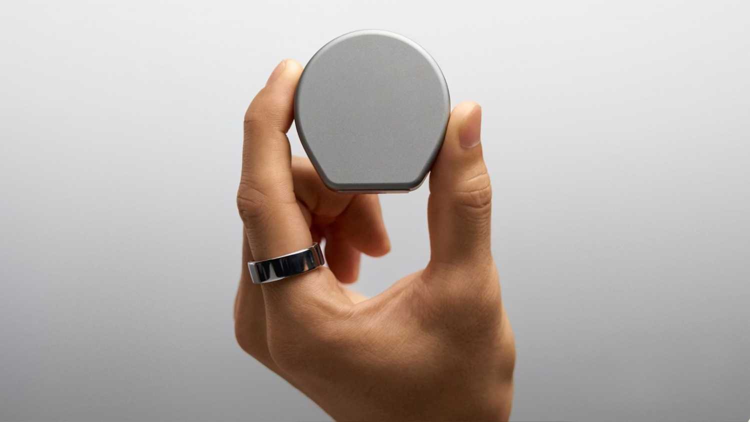 Holding a closed charging case from Oura. 