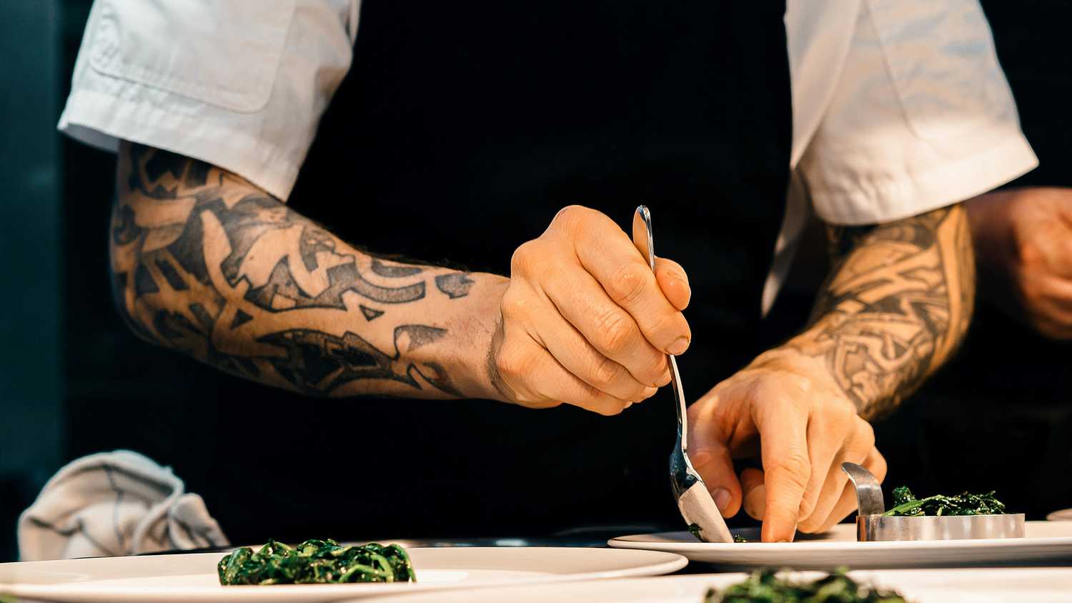 A still photo of a chef's hands preparing food. 