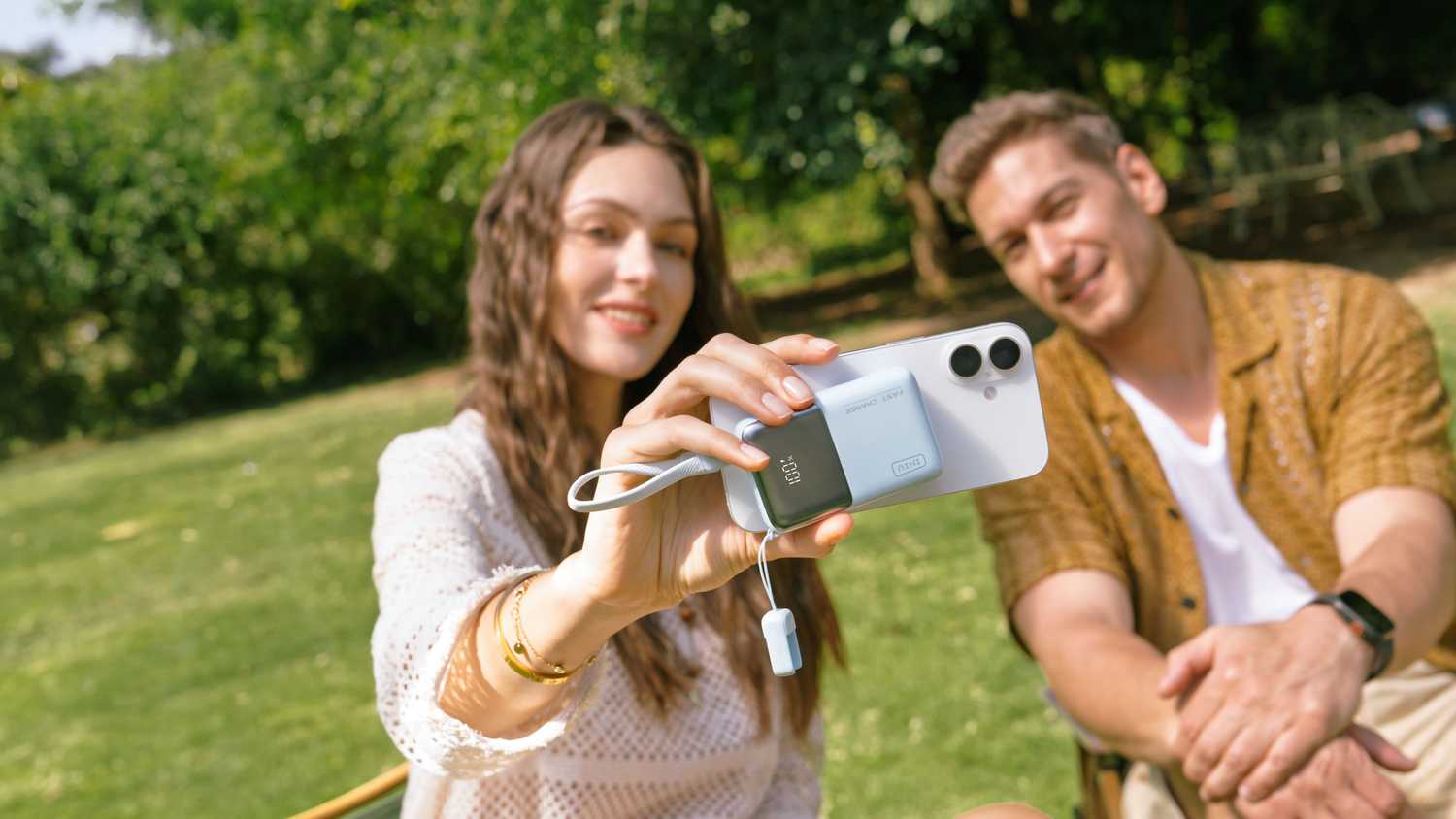 Woman holding a Phone and the INIU Pocket Rocket P50 beside man
