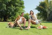 Couple sitting on chairs, woman holding a phone with the INIU Pocket Rocket P50 attached