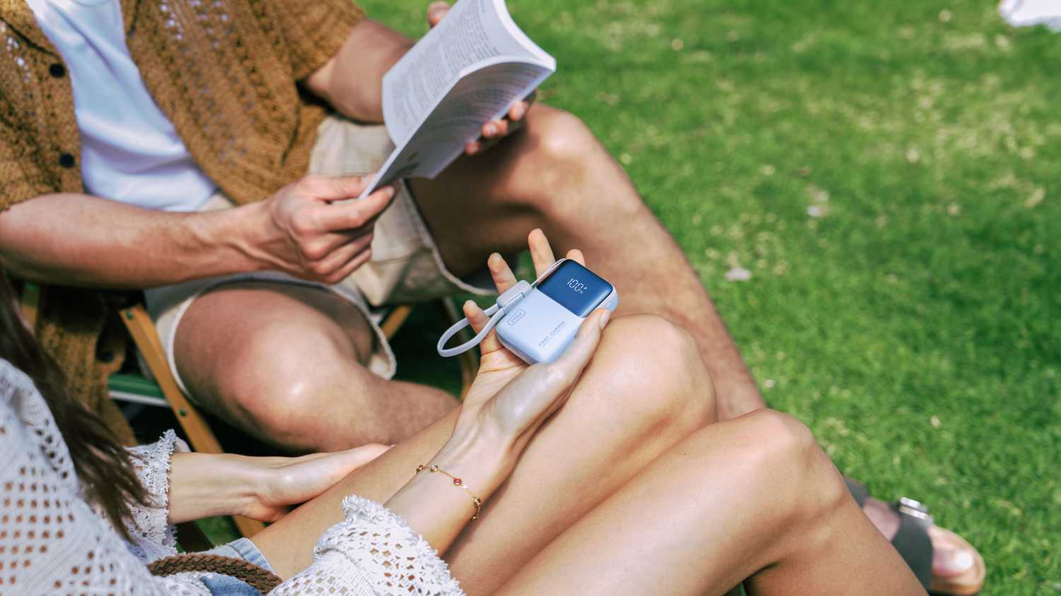 Woman holding the INIU Pocket Rocket P50 next to man with an open book