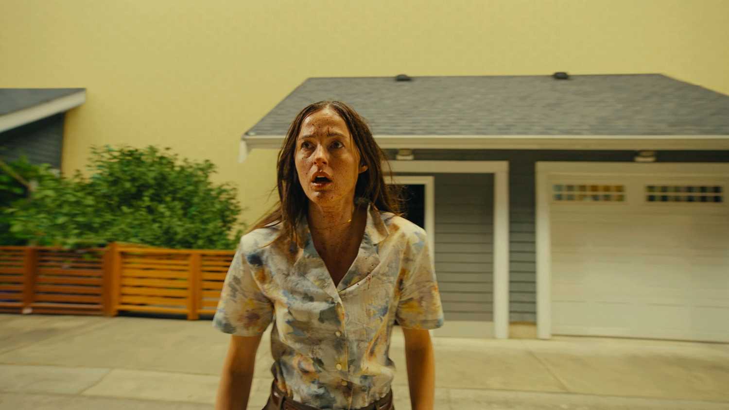 Renate Reinsve standing outside a house in Backrooms