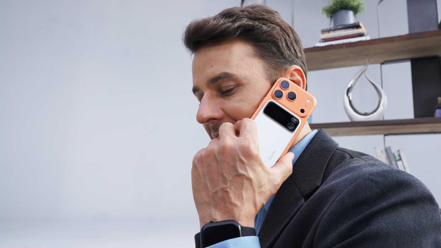 Man taking a call with the Comu Action Pro attached to his phone.