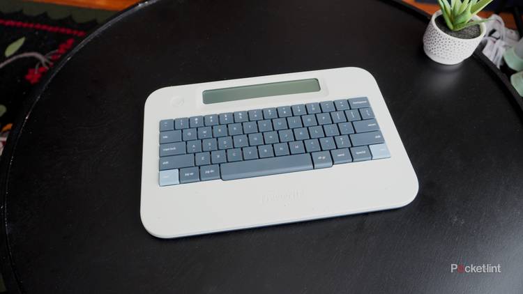 The white and gray Freewrite Alpha on a black coffee table.