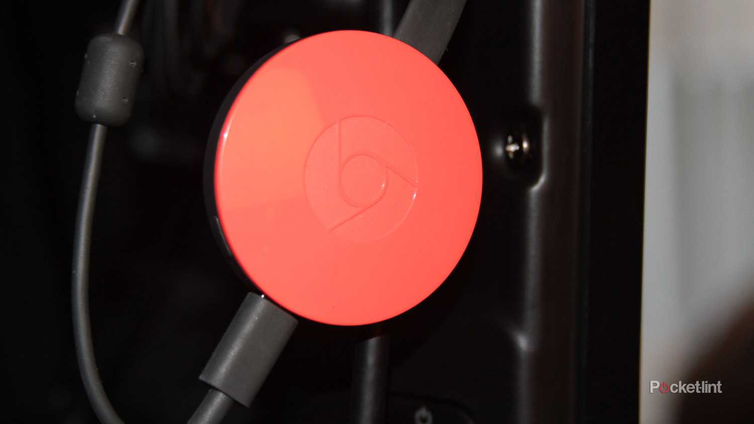 An orange Google Chromecast.