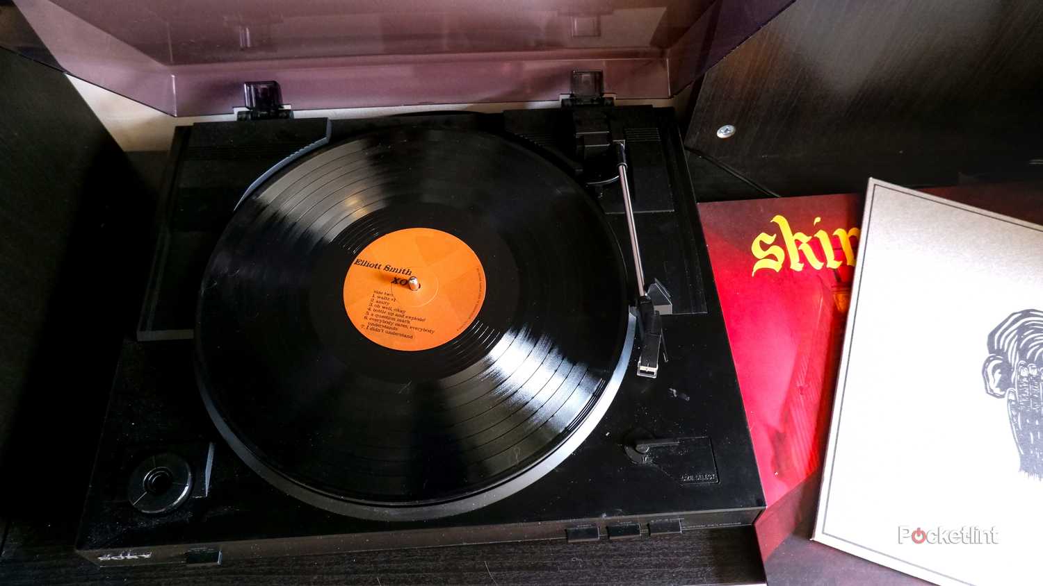 A Sony record player with an Elliott Smith record inside, with a Spruce Trap and Fontaines DC record on the side.