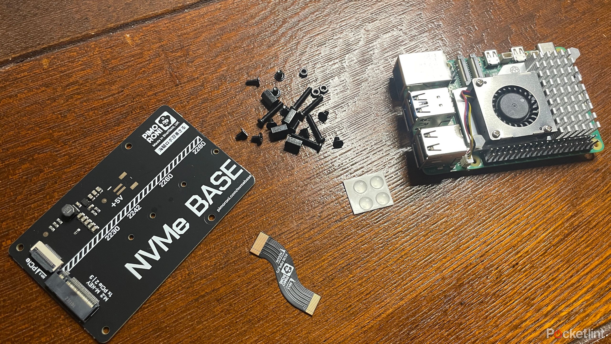 Pimoroni NVMe Base and its components next to Raspberry Pi 5
