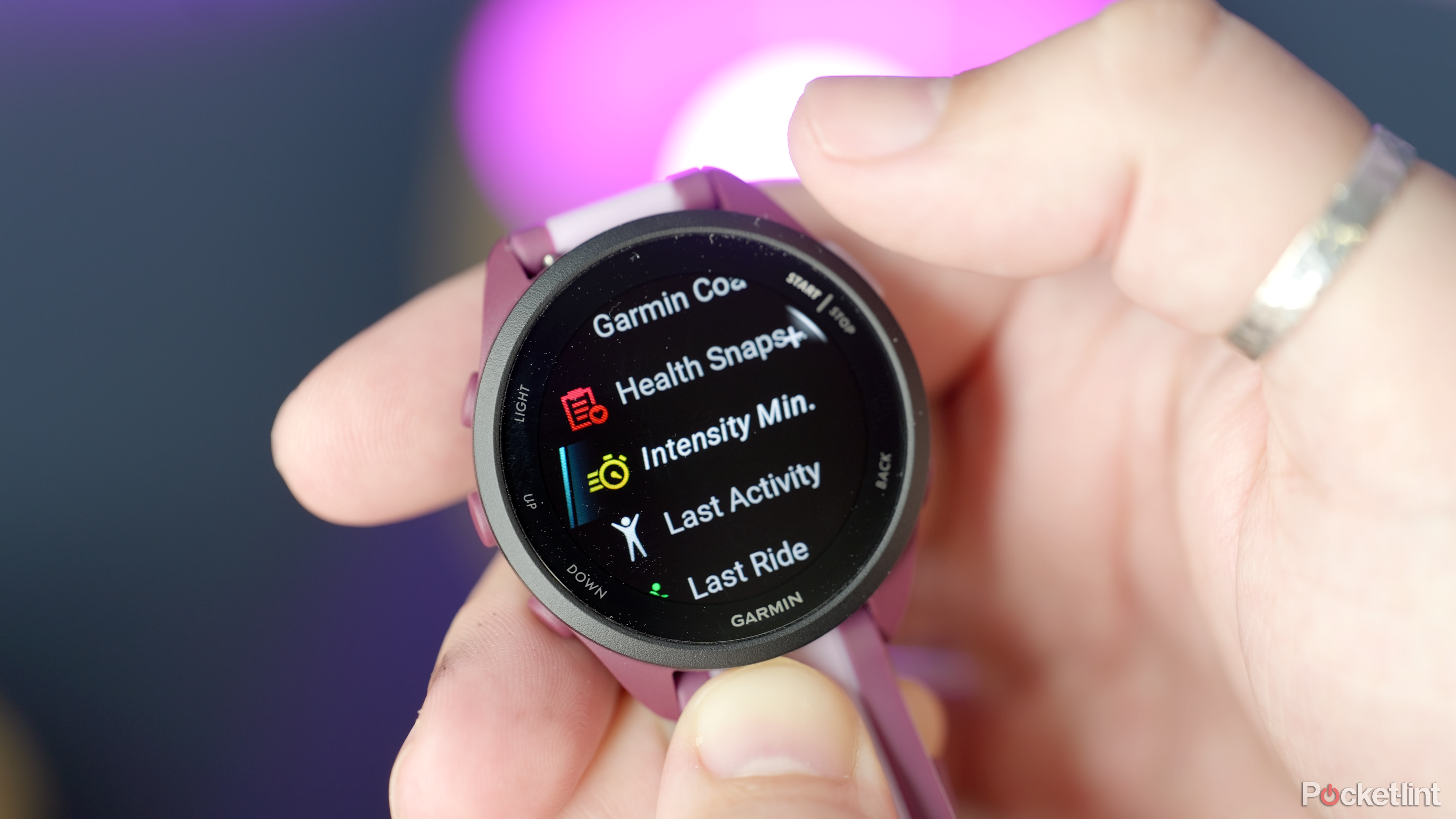 一个人手里拿着 Garmin Forerunner 165
