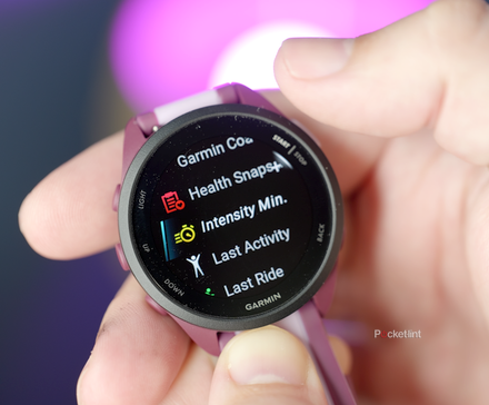 一个人手里拿着 Garmin Forerunner 165