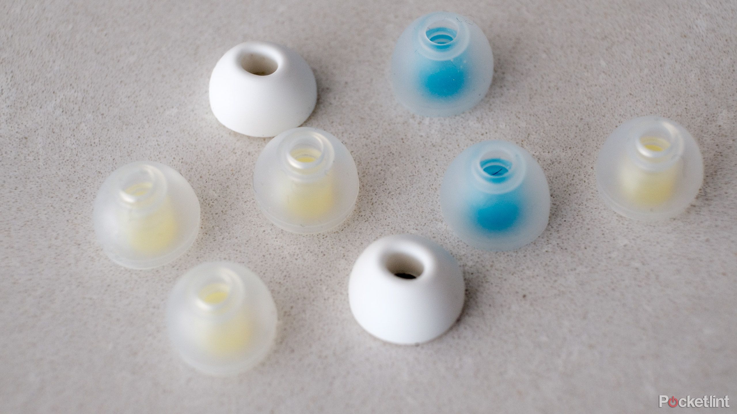A collection of SpinFit ear tips sit on a marble countertop