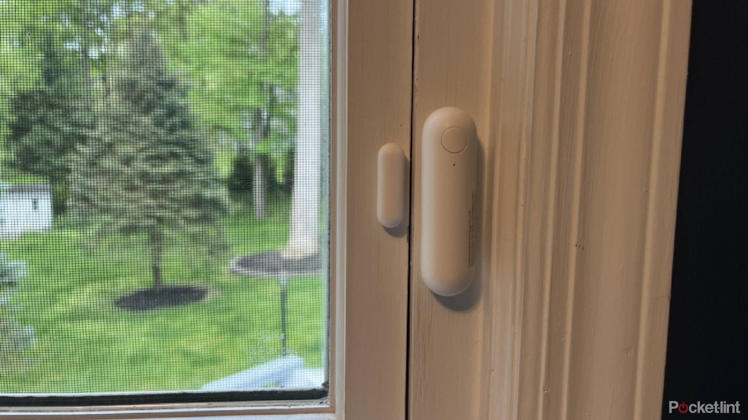 An Aqara door and window sensor P2 installed on a white window frame.
