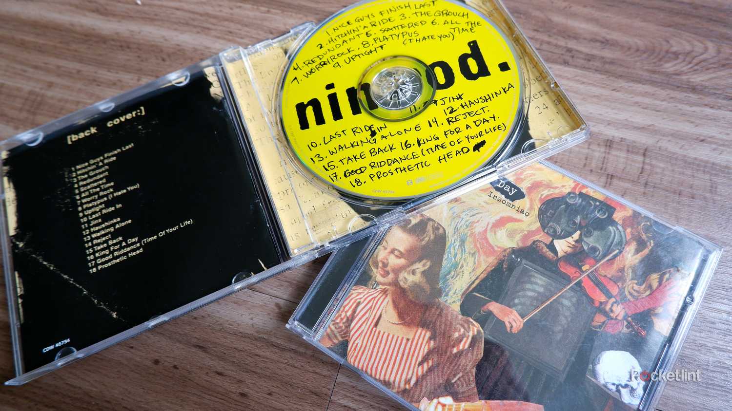 Two Green Day CD cases, one open and resting on top of the other.