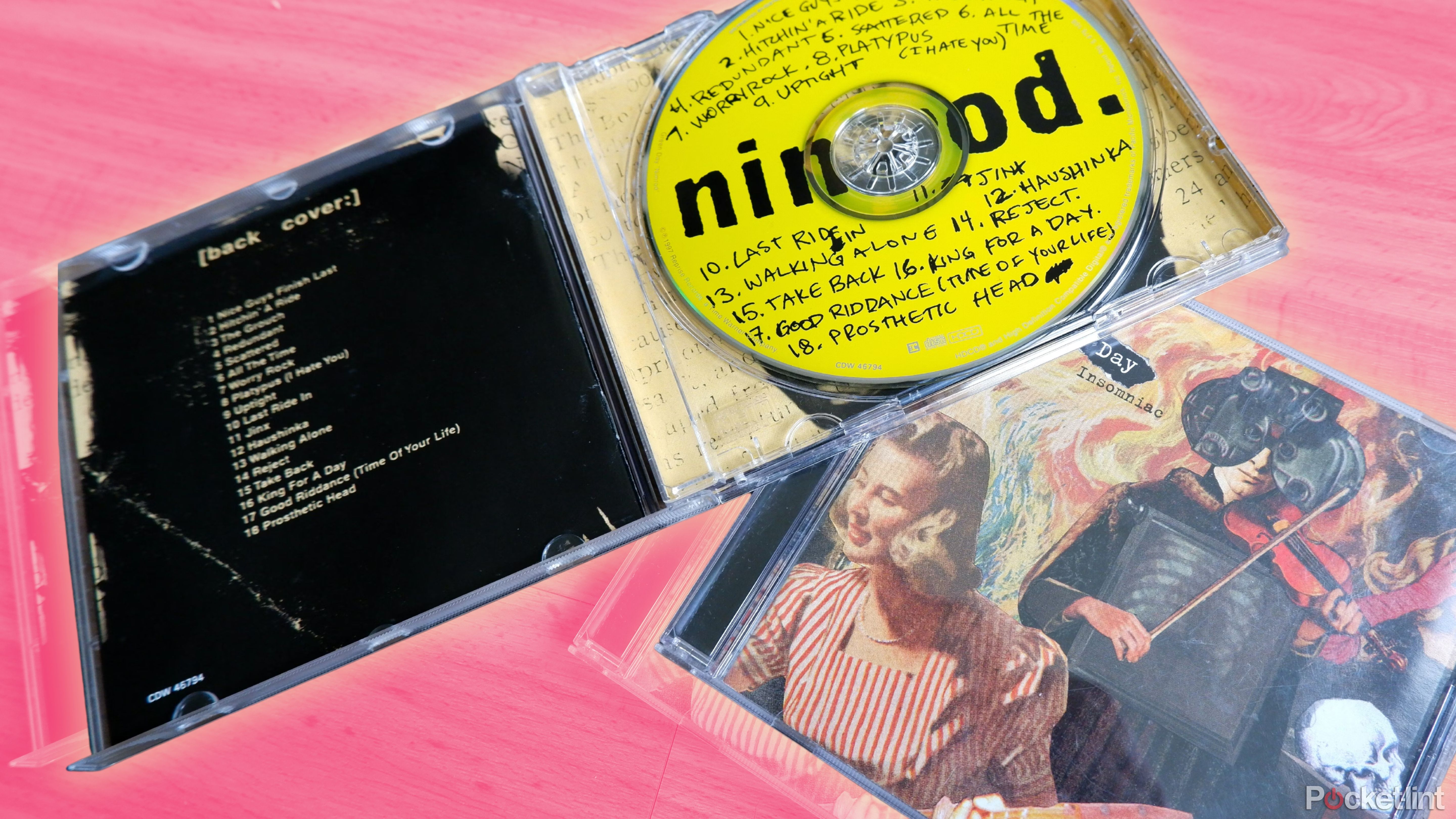 Two Green Day CD cases, one open and resting on top of the other.