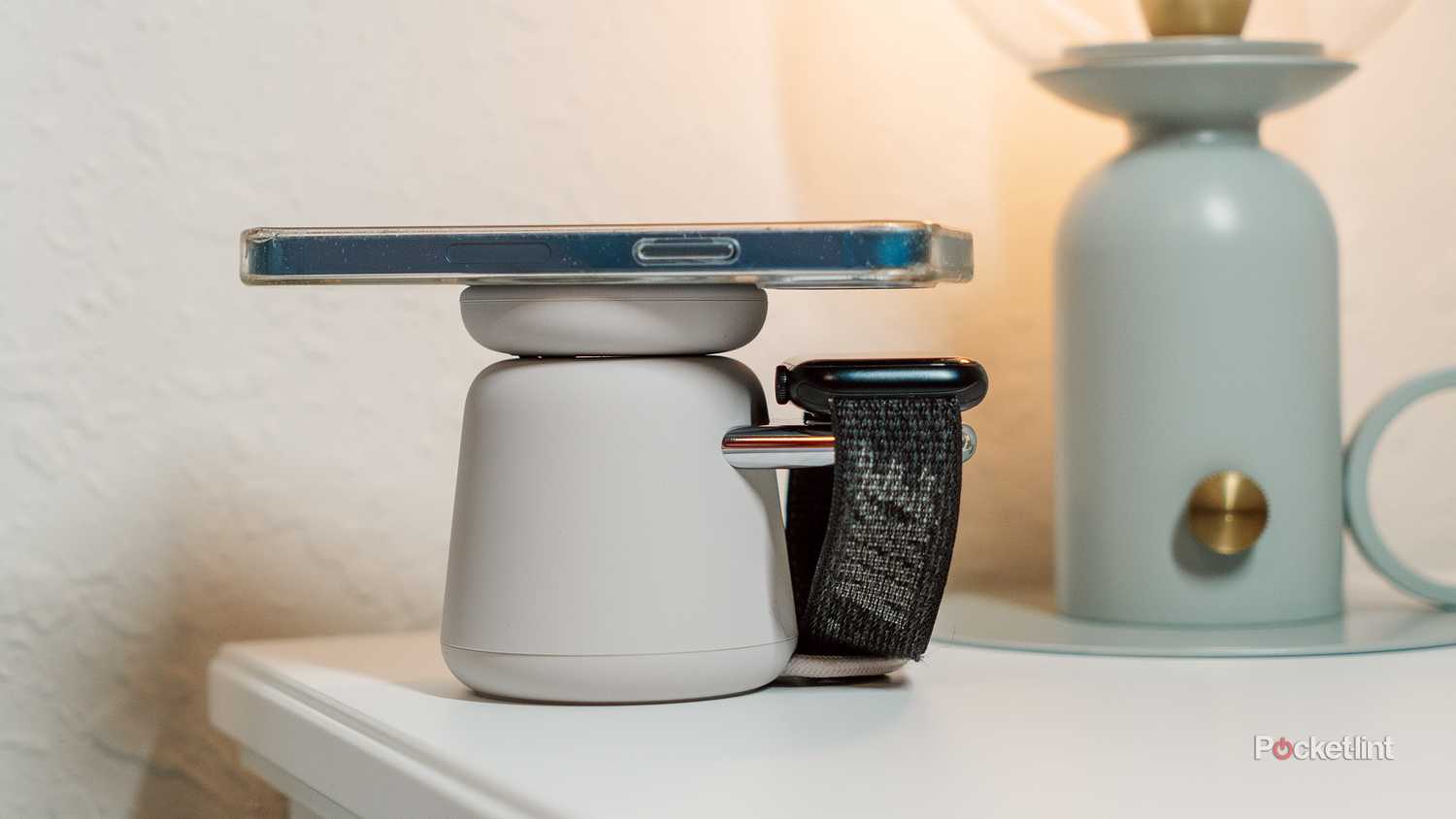 A nightstand with the Belkin Boost Charge Pro charging dock with an iPhone and Apple Watch on it. 
