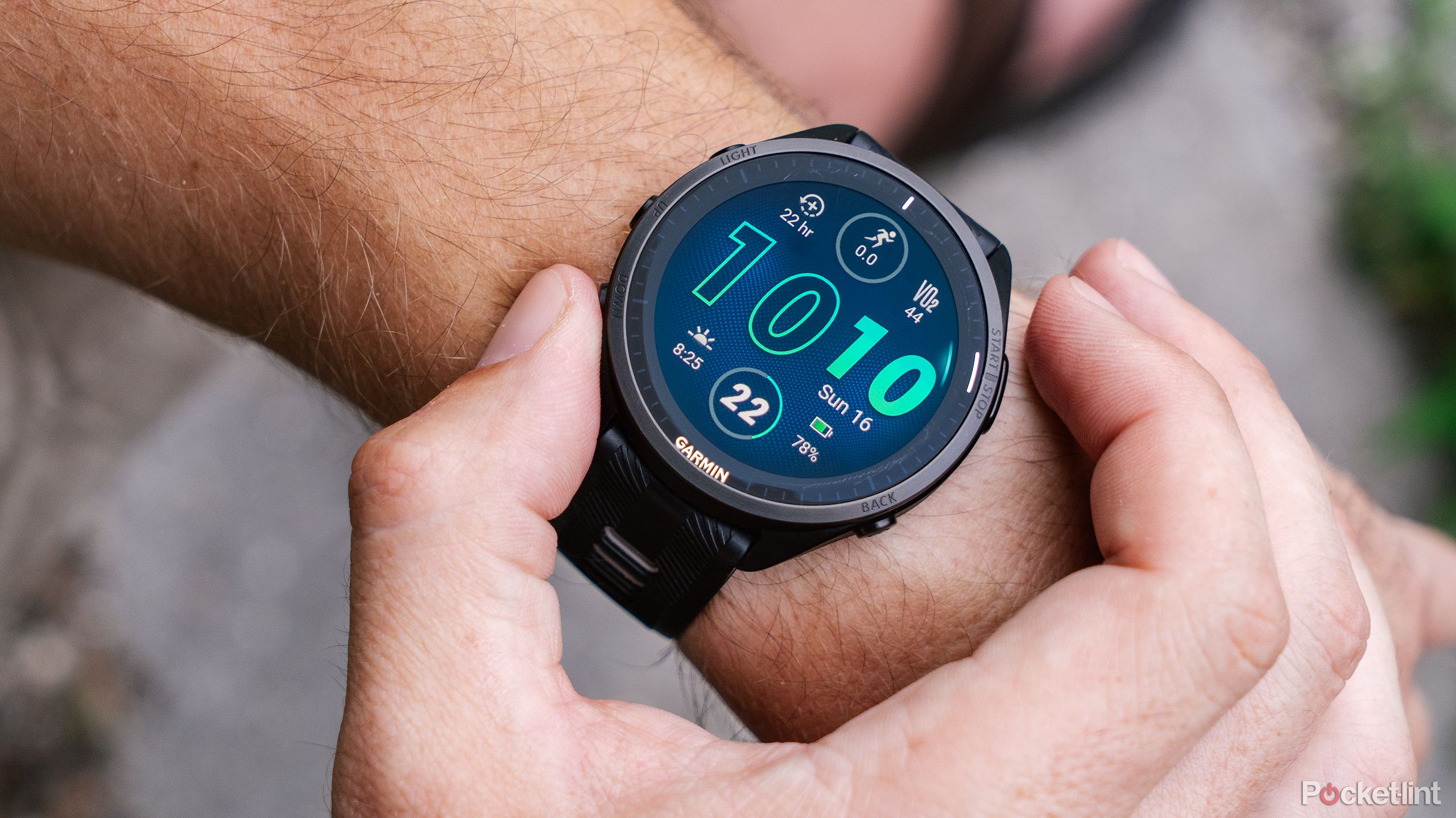 A hand pushes buttons while the Garmin Forerunner 965 is on a wrist. 