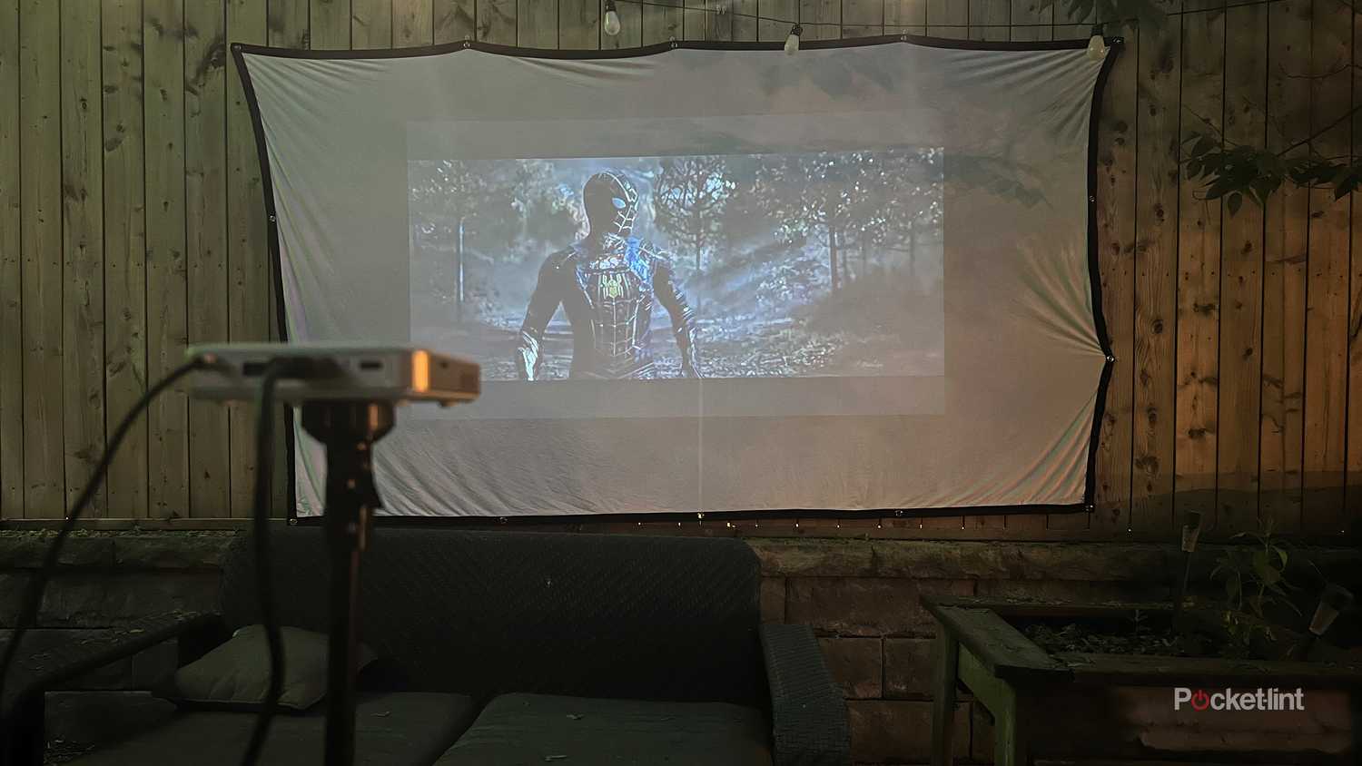 Spiderman being thrown on an outdoor movie projector. 
