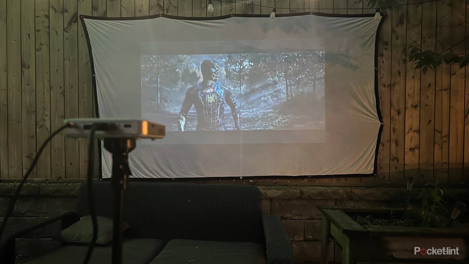Spiderman being thrown on an outdoor movie projector. 