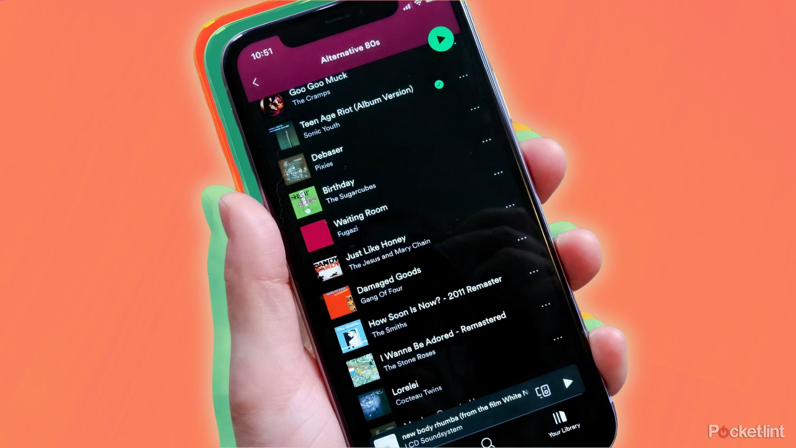 Someone holding an iPhone with Spotify on it. 