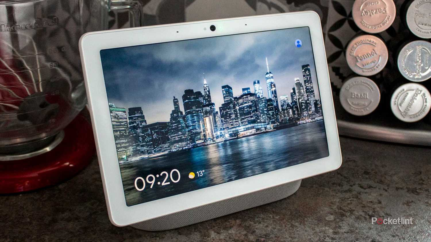 Google Nest Hub Max displaying a city at night covered in cloud cover. 